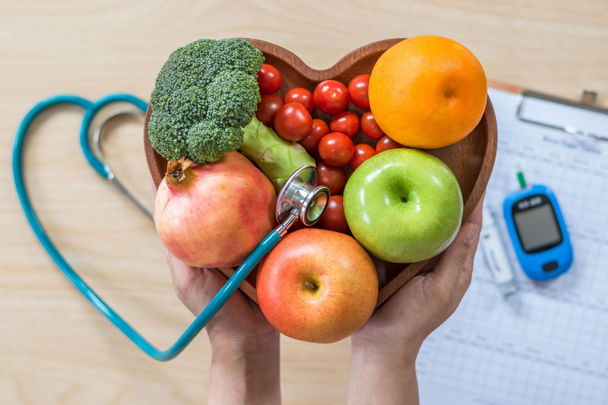 A vibrant spread of fresh fruits and vegetables on a rustic wooden table.